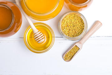 Fototapeta na wymiar Honey in jar with honey dipper on wooden background