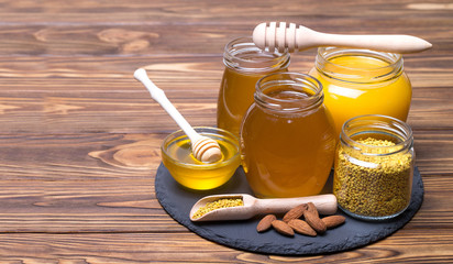 Honey in jar with honey dipper on wooden background