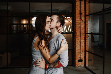 Young stylish hipsters couple. guy and girl in love hugging together. Indoors. Portrait. interior in style the loft. lifestyle moments at home 