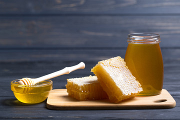  Honey in jar with honey dipper on wooden background