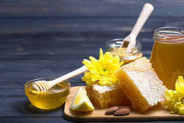 Honey in jar with honey dipper on wooden background