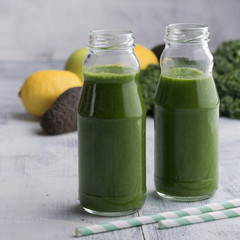 Healthy green vegetable detox smoothies in a glass bottles. Vegan cucumber, parsley green juice.