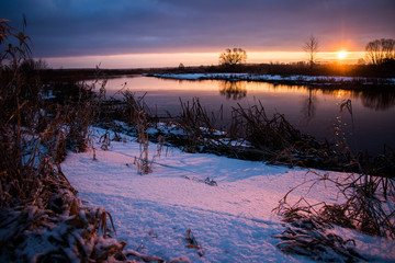 amazeing coloured winter sunrise against snowy river