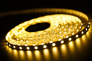 Coil of a diode strip with light on a dark background.