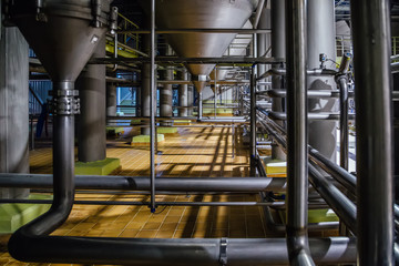 Industrial stainless steel pipes connected with filtration vats. Modern brewery production line