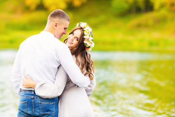 The girl hugs her boyfriend behind the waist and looks back and