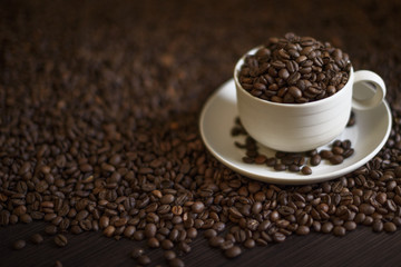 Coffee cup and coffee beans on wooden table