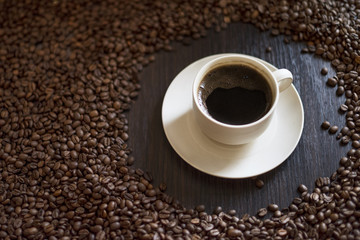 Coffee cup and coffee beans on wooden table