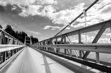 Suspension bridge over the water runoff of General Carrera Lake, near Lake Bertrand, Puerto Tranquilo, Chile Chico, Aysen,  Chile, monochrome.