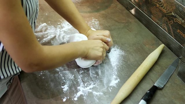 Woman's hands knead sugar mastic for making dessert
