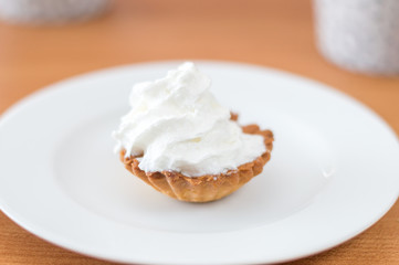 Polish babeczka cake with whipped cream on white plate.