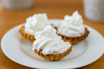 Polish babeczki cake with whipped cream on white plate.