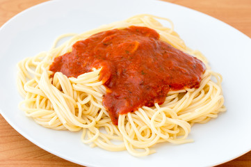 Simple tomato spaghetti on white plate.