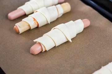 Wrapped sausage with cheese and ketchup in raw puff pastry.