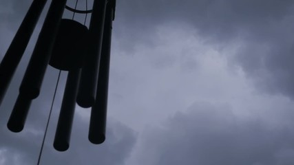 Wind chimes with thunder storm clouds in the background.