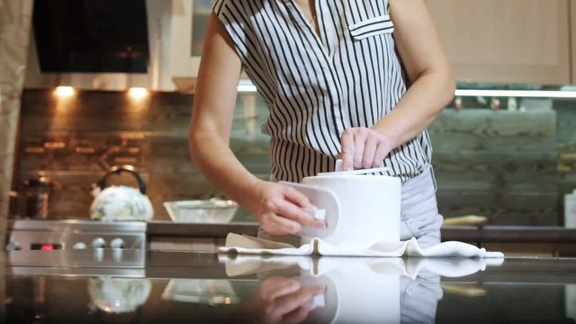 Woman covering a round cake with fondant icing