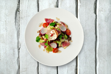 Salad on a plate on white wood texture