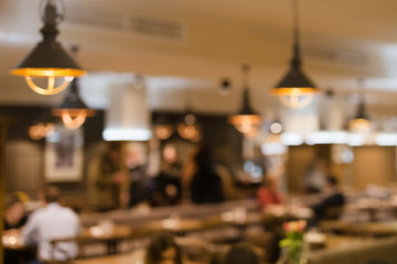 Obraz na płótnie Canvas Blurred abstract restaurant background. Warm evening colors of cafe interior. Vintage defocused bar hall