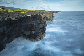 view of the volcanic rock cliff tops on the big island of hawaii in the pacific ocean showing the...