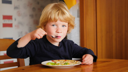 Young boy on table eating