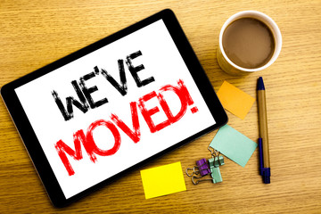 Handwritten text caption showing We Have Moved. Business concept writing for Company Changing Place Written on tablet laptop, wooden background with sticky note, coffee and pen