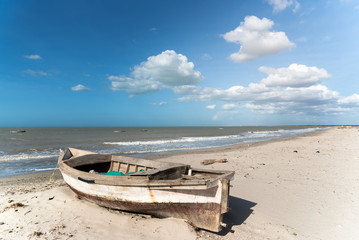 Fototapeta na wymiar abandoned fishing boat on the shore of a beach in Colombia