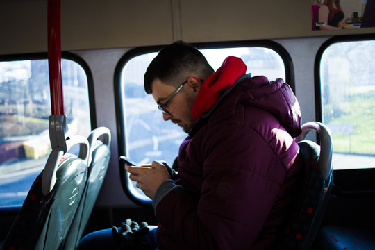 Guy On The Bus Looking At Phone.