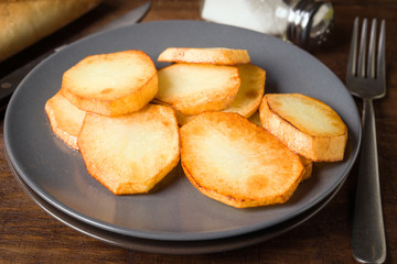 roasted potatoes sliced in porcelain dish on wood