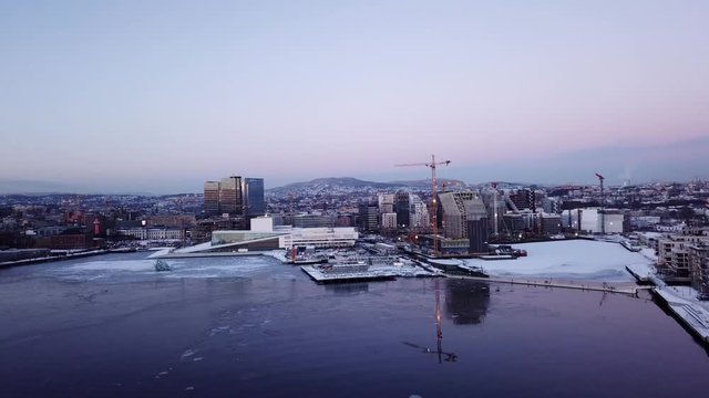 Aerial moving away shot of Opera and Lambda Munch museum in Oslo, Norway in winter