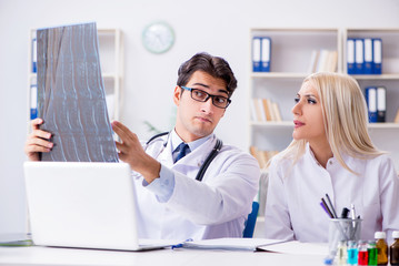 Two doctors examining x-ray images of patient for diagnosis