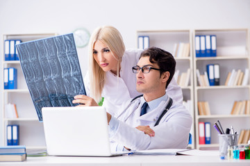 Two doctors examining x-ray images of patient for diagnosis