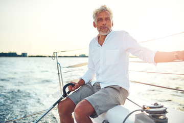 Mature man sitting on the deck of a sailboat