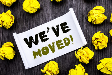 Naklejka premium Writing text showing We Have Moved. Business concept for Company Changing Place Written on sticky note notepad note notebook book wooden background with yellow sticky folded.