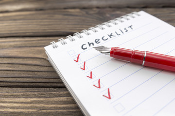 checklist, pen on a wooden background. business. finance. planning.