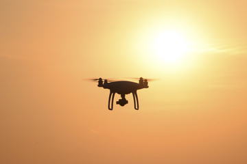Quadrocopters silhouette against the background of the sunset