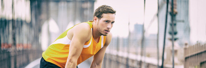 Tired runner taking a break breathing during jogging workout training on Brooklyn bridge in New...