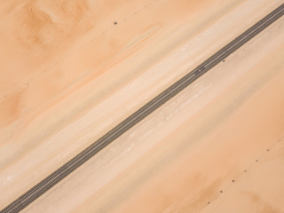 Straight cargo railroad track passing through a sandy desert in the Empty Quarter. Abu Dhabi,...