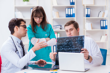 Fototapeta premium Three doctors discussing scan results of x-ray image