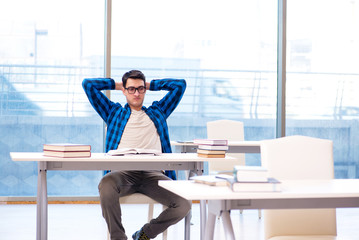 Student studying in the empty library with book preparing for ex