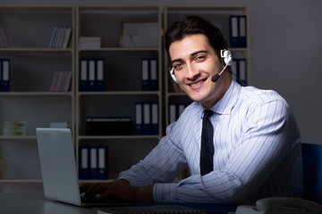 Call center operator talking to customer during night shift 