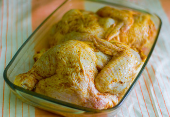 chicken with curry seasoning for frying on a baking tray