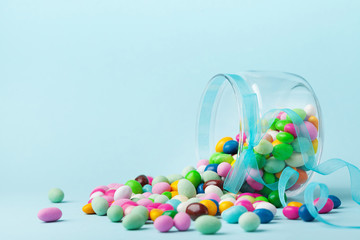 Colorful candy are scattered on blue background. Gifts for Birthday or Happy Easter.