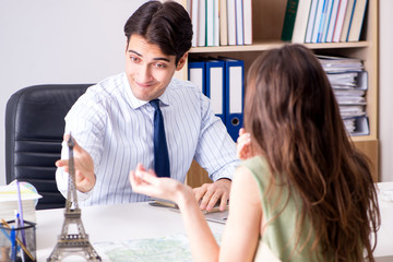 Male travel agent with customer in agency