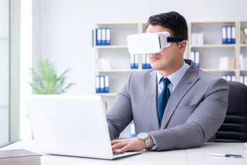 Businessman with virtual reality glasses in modern technology co