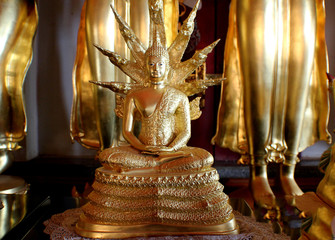 The image of the golden Buddha is surrounded by pagodas.