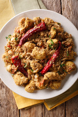 Indian spicy chettinad chicken curry with chili pepper closeup on a table. Vertical top view