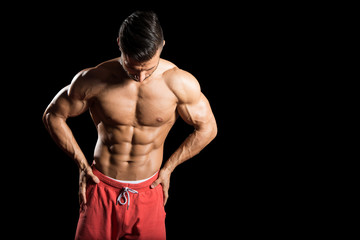 Fototapeta na wymiar Muscular Men Flexing Muscles On Black Background