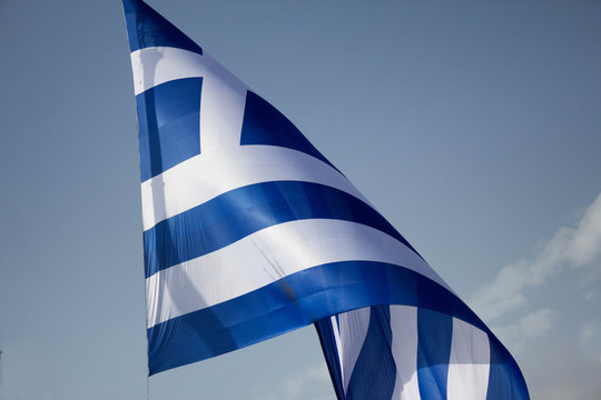 A gigantic Greek flag hangs from a crane in Syntagma square, Athens, Greece.