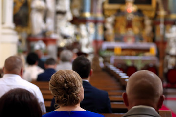 People are sitting in the church during mass - obrazy, fototapety, plakaty
