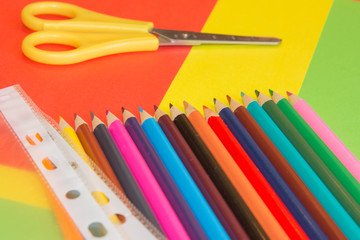 Bright colored wooden pencils on a Colored background. The sharp tips of the pencils